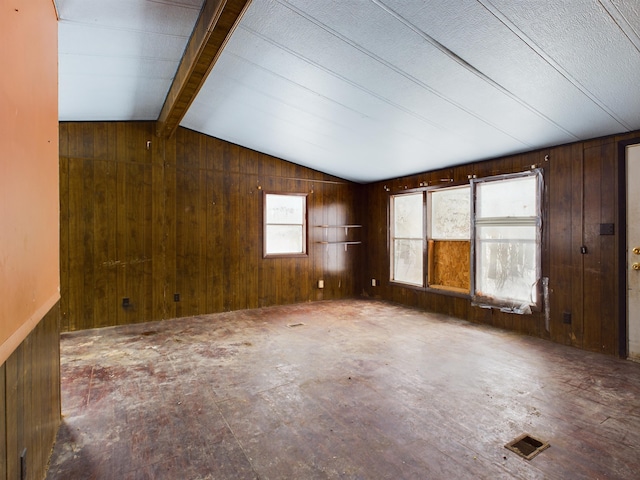 spare room with vaulted ceiling with beams