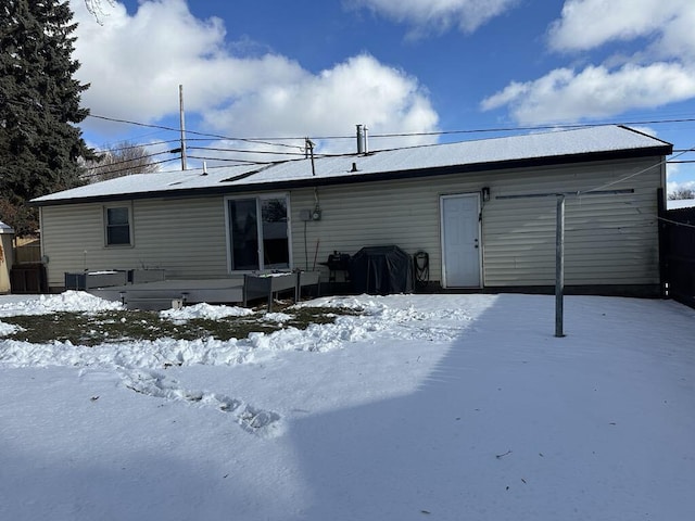 view of snow covered back of property