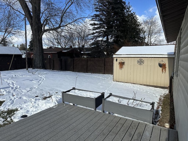 snow covered deck with a storage shed