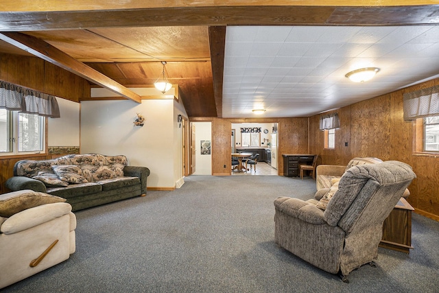 carpeted living room featuring wooden walls and beamed ceiling