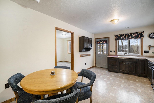 dining area featuring sink and a textured ceiling