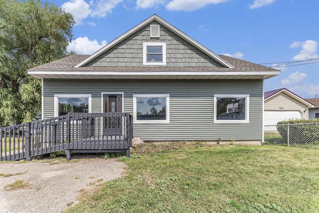 back of house with a deck and a yard