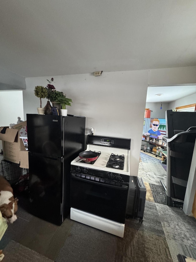 kitchen featuring range with gas cooktop and black fridge