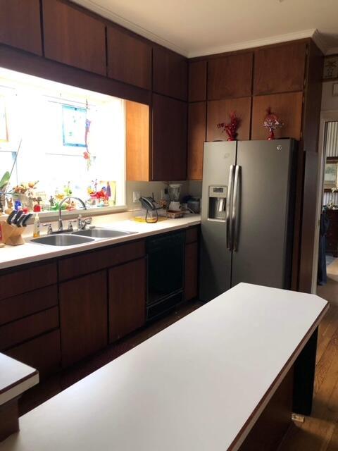 kitchen featuring stainless steel refrigerator with ice dispenser, black dishwasher, dark hardwood / wood-style floors, and sink