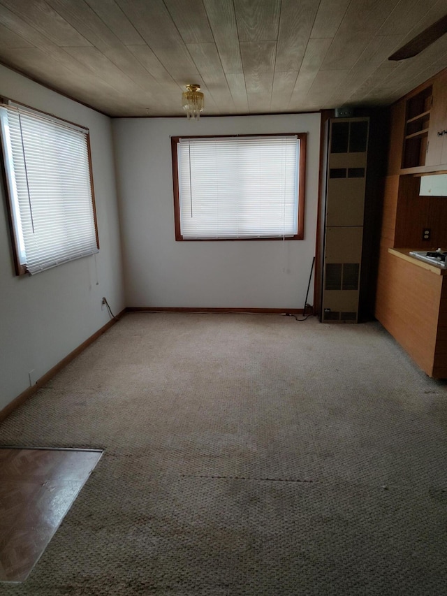 spare room featuring wood ceiling and carpet flooring