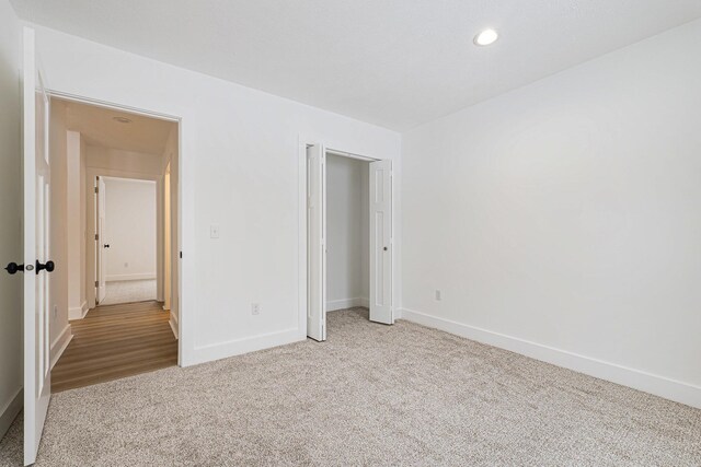 unfurnished bedroom featuring a closet and light carpet