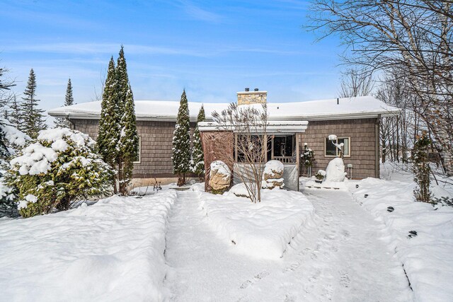 snow covered rear of property featuring a balcony