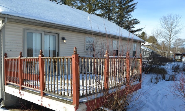 snow covered property with a deck