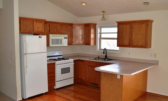 kitchen featuring sink, white appliances, kitchen peninsula, and light wood-type flooring