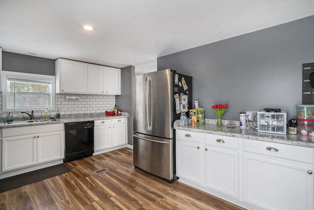 kitchen with sink, white cabinetry, dark hardwood / wood-style floors, black dishwasher, and stainless steel refrigerator