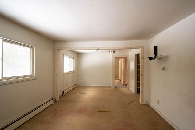 unfurnished room with light colored carpet and baseboard heating