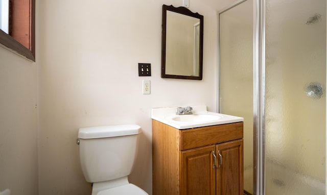 bathroom featuring vanity, an enclosed shower, and toilet