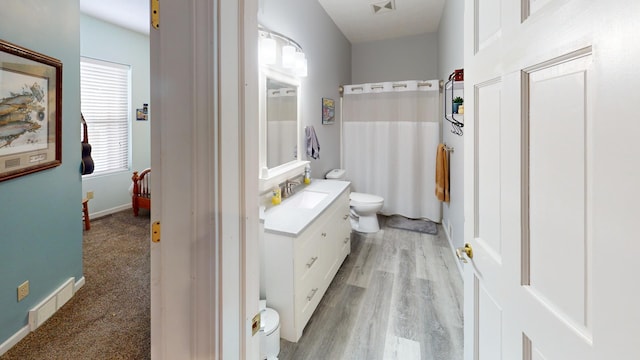 bathroom with wood-type flooring, toilet, walk in shower, and vanity