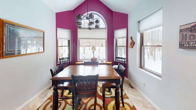 dining space with light tile patterned flooring, plenty of natural light, and lofted ceiling