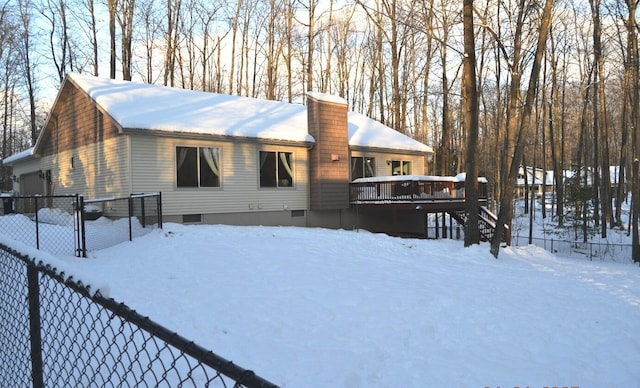 snow covered house with a deck