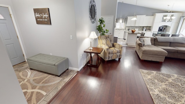 living room with lofted ceiling, dark hardwood / wood-style floors, and a notable chandelier