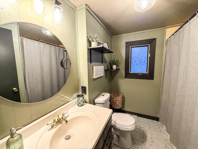 bathroom featuring vanity, toilet, crown molding, tile patterned floors, and a textured ceiling