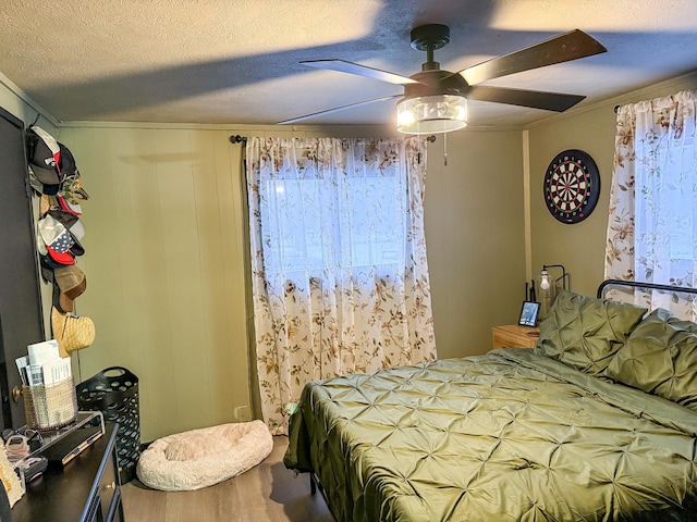 bedroom with ceiling fan and a textured ceiling