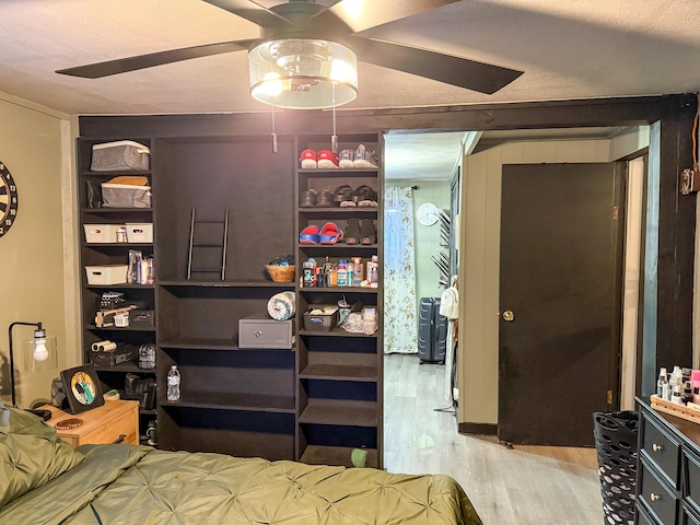 bedroom featuring ceiling fan, light hardwood / wood-style floors, and a textured ceiling