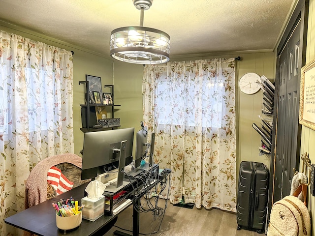 office area with crown molding, a notable chandelier, a textured ceiling, and light hardwood / wood-style flooring