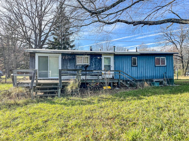 view of front of property with a wooden deck and a front lawn