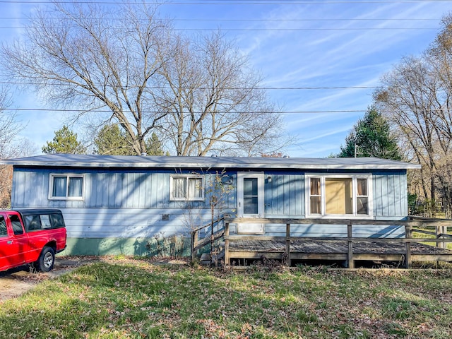 view of front facade with a wooden deck and a front yard