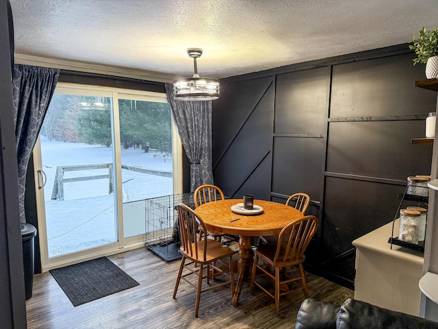 dining space featuring hardwood / wood-style flooring and a textured ceiling