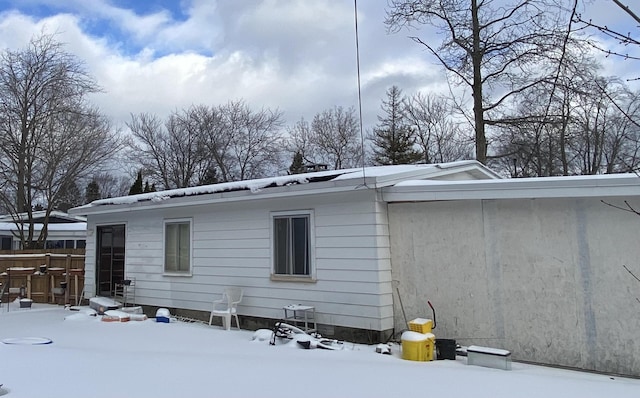 view of snow covered back of property