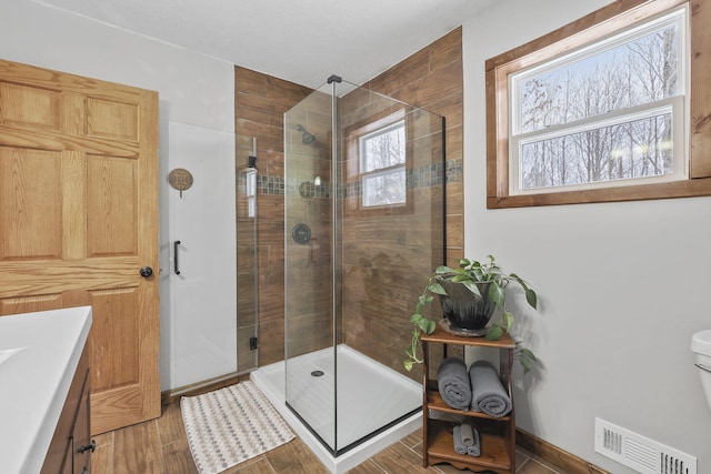 bathroom featuring walk in shower, vanity, and toilet