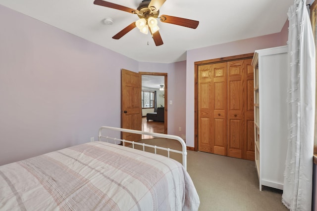 carpeted bedroom with ceiling fan and a closet