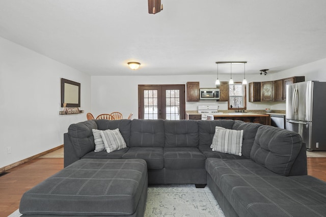 living room featuring french doors and light hardwood / wood-style flooring