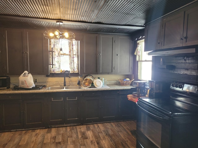 kitchen with pendant lighting, black electric range oven, sink, dark hardwood / wood-style floors, and light stone counters