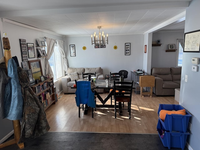 dining area with crown molding, wood-type flooring, and a chandelier