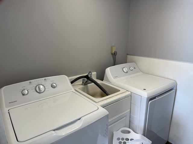 clothes washing area with cabinets and separate washer and dryer