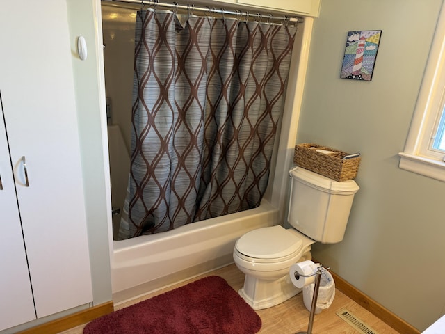 bathroom featuring wood-type flooring, shower / bath combo, and toilet