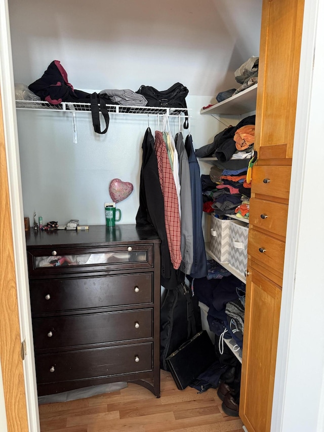 walk in closet with light hardwood / wood-style floors