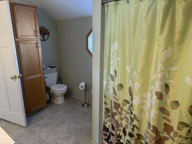 bathroom with toilet and a shower with shower curtain