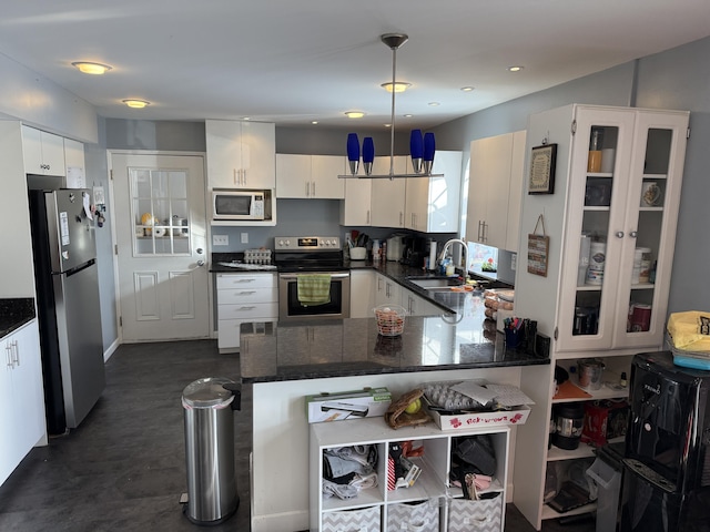 kitchen featuring sink, decorative light fixtures, appliances with stainless steel finishes, kitchen peninsula, and white cabinets