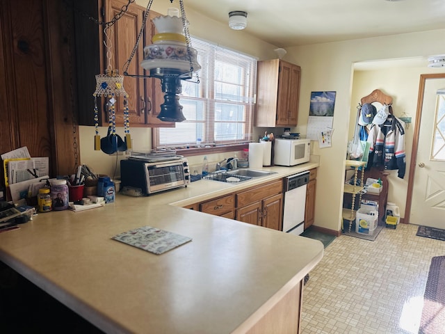 kitchen featuring sink, white appliances, and kitchen peninsula