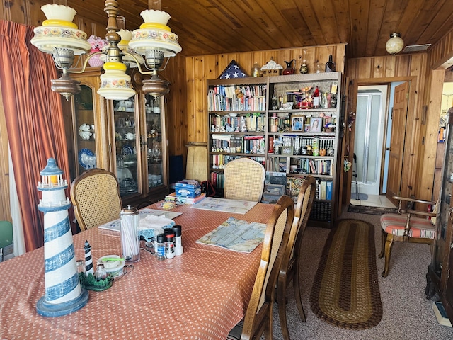 dining area featuring wood ceiling, wooden walls, and carpet