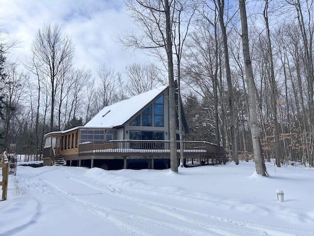 snow covered house featuring a deck