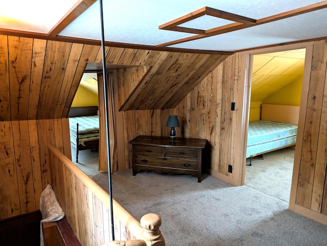 unfurnished bedroom featuring lofted ceiling, carpet floors, and wood walls