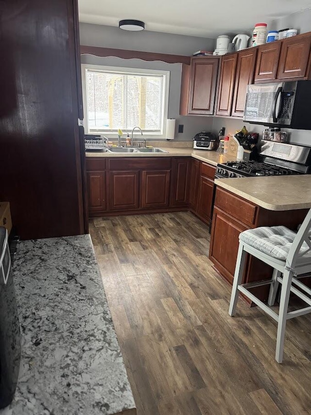 kitchen with sink, stainless steel appliances, and dark hardwood / wood-style floors