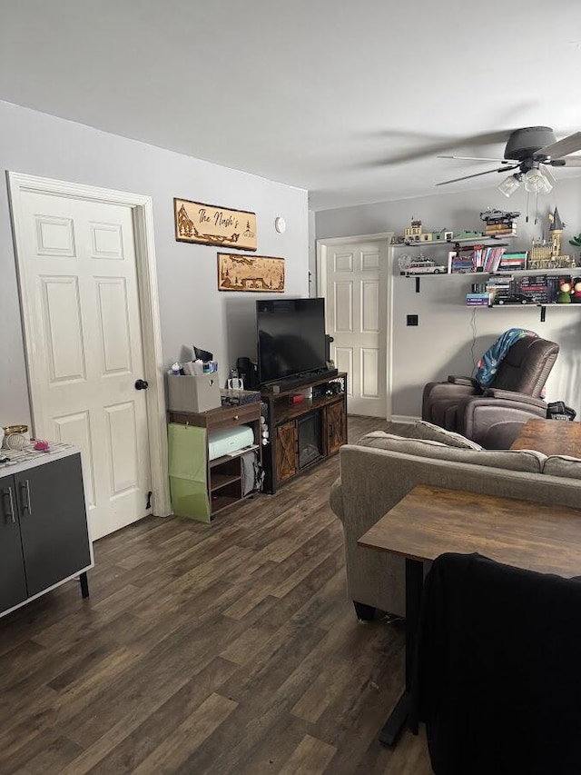 living room with dark wood-type flooring and ceiling fan