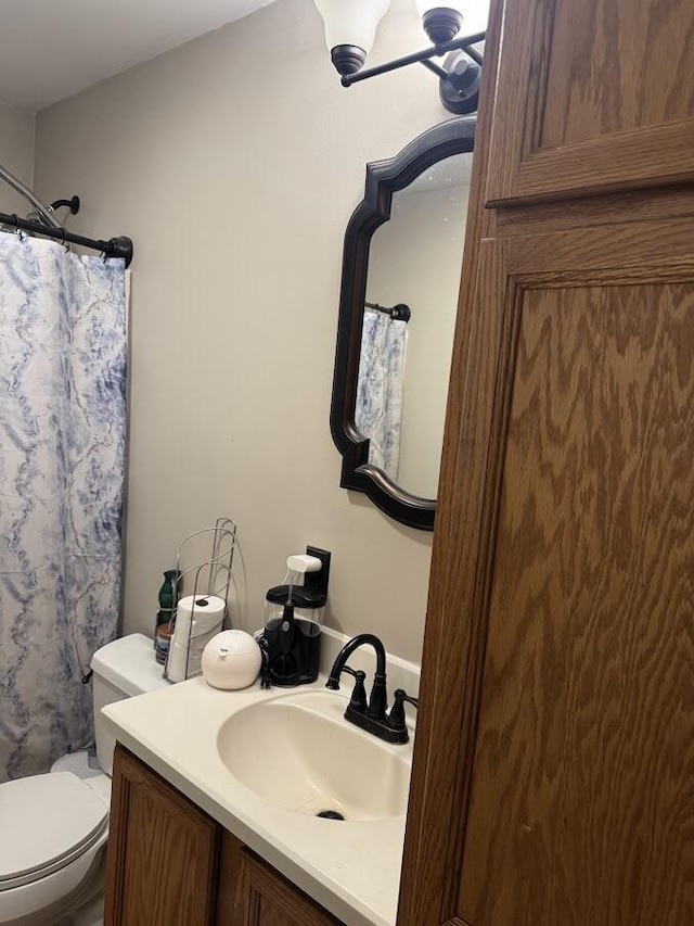 bathroom featuring a shower with curtain, vanity, and toilet