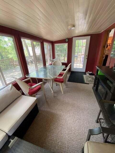 carpeted dining space with wood ceiling and wooden walls