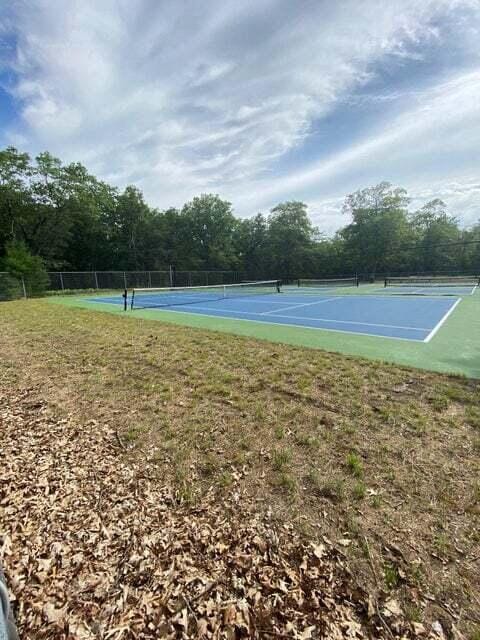 view of sport court featuring a lawn