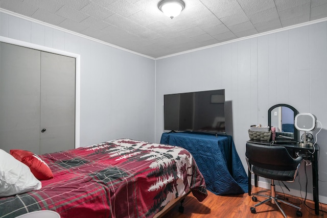 bedroom featuring ornamental molding, hardwood / wood-style floors, and a closet