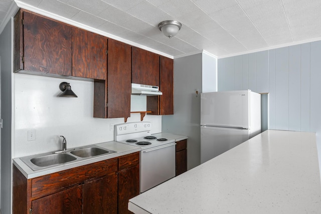 kitchen with crown molding, sink, wooden walls, and white appliances