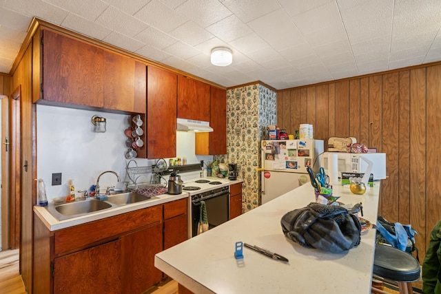 kitchen featuring white appliances, ornamental molding, sink, and wood walls